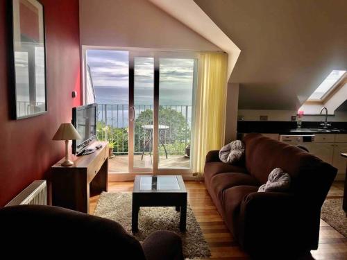 a living room with a couch and a large window at Isle of Wight Seaview in Shanklin