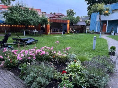 a garden with pink flowers in a yard at Villa Meri Apartments in Pärnu