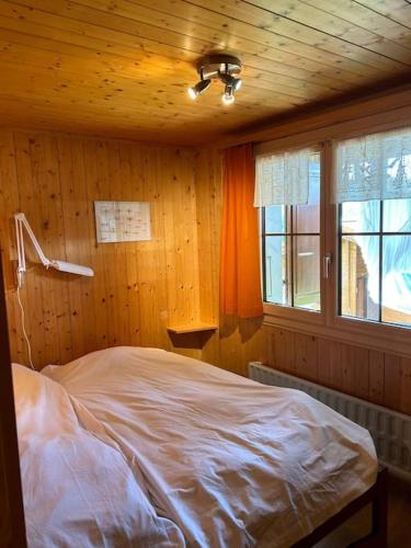 a bedroom with a bed in a wooden room at Chalet Glücksfall in Bellwald