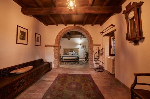 a hallway with an archway with a bed and a clock at Casale Alessandri in Massa Martana