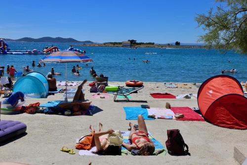 a group of people laying on the beach at APARTMAN MAKSAN in Pakoštane