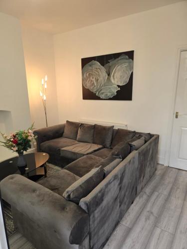 a living room with a large couch and a table at Realwood Homes- Broomhill Road in Nottingham