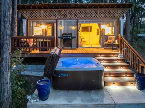 un jacuzzi en la terraza de una casa en Tiny home with spa/firepit/and more, en Yosemite Forks