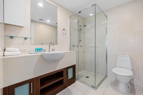 a bathroom with a toilet and a sink and a shower at The Pool Resort Kingscliff - Private Apartments by Holiday Management Company in Kingscliff