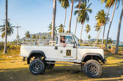 a woman driving a white truck with palm trees at Sichon Cabana Beach Resort in Sichon