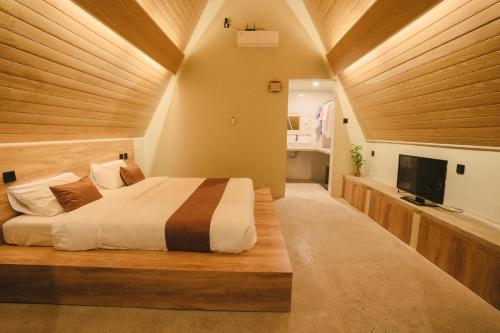 a bedroom with a large bed and a television at Maya Ocean Resort in Selong Belanak