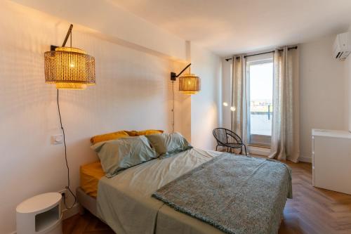 une chambre avec un lit avec deux lampes et une fenêtre dans l'établissement Le 17 - Centre historique avec garage -, à Avignon