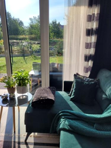 a living room with a couch and a large window at Apartament Nina in Jelenia Góra