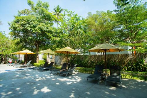 a group of chairs and umbrellas on a patio at Sichon Cabana Beach Resort in Sichon