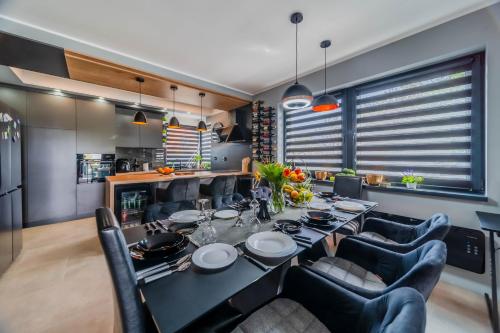 a dining room with a black table and chairs at Villa Joy With Pool and Hot Tub - Happy Rentals in Sračinec