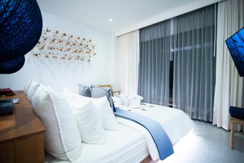 a bedroom with a bed with white sheets and pillows at Sichon Cabana Beach Resort in Sichon