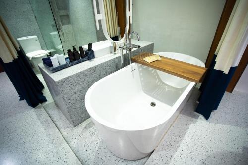 a bathroom with a white tub and a sink at Sichon Cabana Beach Resort in Sichon