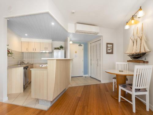a kitchen with a table and a dining room at The Pool Resort Kingscliff - Private Apartments by Holiday Management Company in Kingscliff