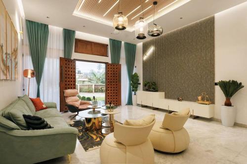 a living room with a couch and chairs and a table at Infinity Beach Villa by EWA Properties in Manjeshwara