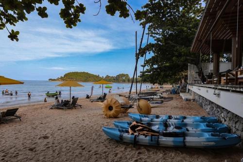 a beach with blue kayaks and people on the beach at Sichon Cabana Beach Resort in Sichon