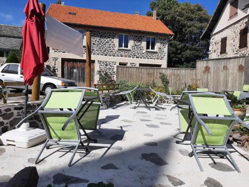 un groupe de chaises et de tables sur une terrasse dans l'établissement la chaumière des barthes, à Laussonne