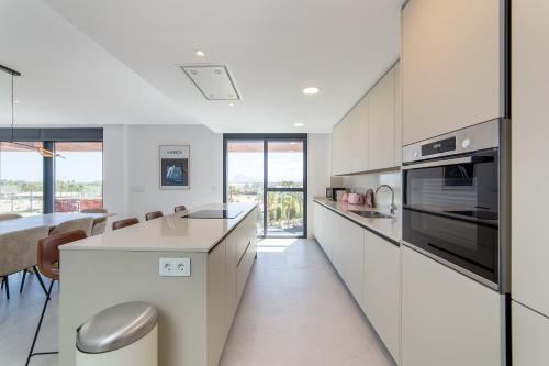 a kitchen with white cabinets and a counter top at Oceans Oliva in Oliva