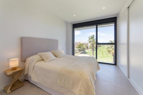 a bedroom with a bed and a large window at Oceans Oliva in Oliva