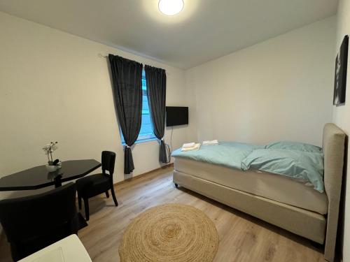 a bedroom with a bed and a desk and a table at City Ferien Wohnungen 3 in Rosenheim