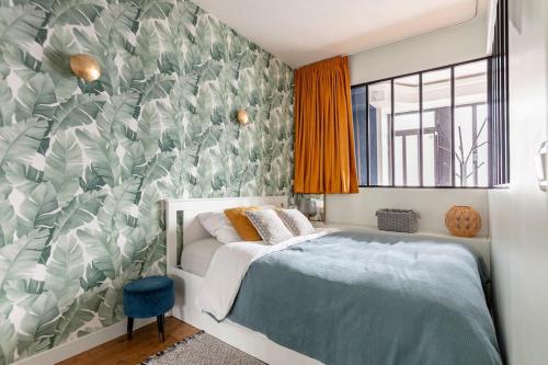 a bedroom with a bed and a green and white wall at Appartement rénové une chambre avec espace de travail in Suresnes