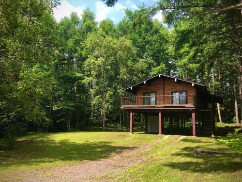 a log cabin in the middle of a forest at 『一軒丸々貸切』徒歩5分圏内カフェ 自然を満喫 Modern Ski Chalet +WiFi & 5min walk to cafes. in Nagano