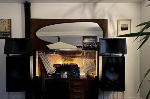 Cette chambre comprend un bureau avec deux haut-parleurs et un miroir. dans l'établissement Unique loft on paris doorstep, à Saint-Denis