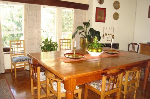 a dining room with a wooden table and chairs at Taunton House B&B in Pietermaritzburg