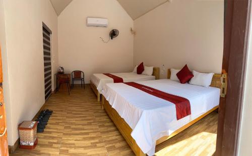 a bedroom with two beds and a table and chairs at Tam Coc Westlake Homestay in Ninh Binh