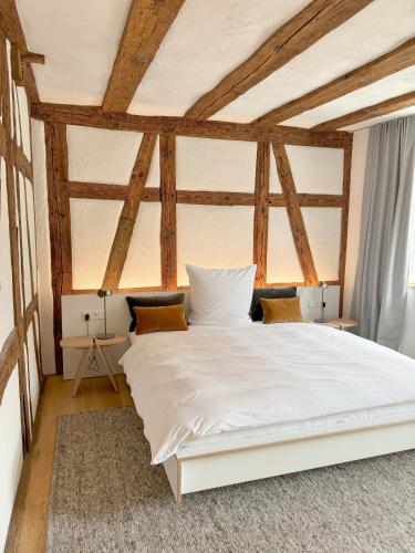 a white bed in a room with wooden ceilings at Gasthaus Faust in Knittlingen