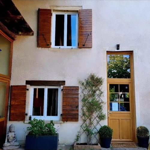 une maison avec des fenêtres, une porte et quelques plantes dans l'établissement Art et cosy, à Savigneux
