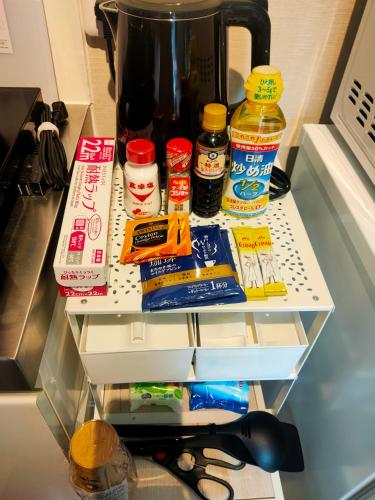 a shelf in a kitchen with food and a coffee pot at 豆インMaMe Inn in Saitama