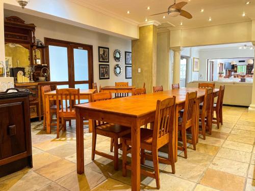 a dining room with a large wooden table and chairs at Telestai Guest House in White River