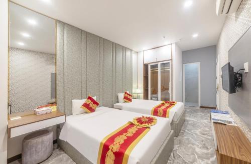 a hotel room with two beds and a television at Tiffany Hotel & Restaurant in Phan Thiet