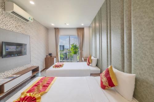 a hotel room with two beds and a window at Tiffany Hotel & Restaurant in Phan Thiet