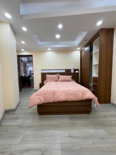 a bedroom with a large bed with pink sheets at Goit Bhawan in Nougām