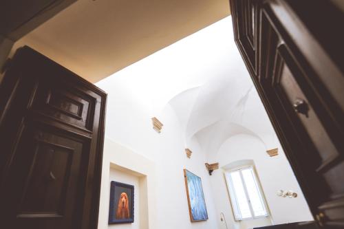 an open door in a hallway with paintings on the wall at Chiama Ride the Beauty Assisi in Assisi