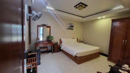 a bedroom with a bed and a table and a mirror at New Sun Hotel Sapa in Sa Pa
