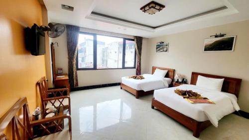 a hotel room with two beds and a television at New Sun Hotel Sapa in Sa Pa