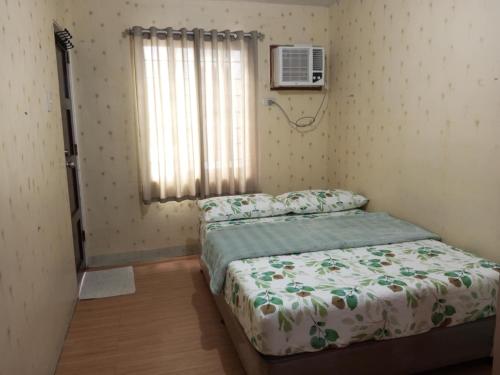 a small bedroom with a bed and a window at comfy Deca homes hernan cortes near sm jmall in Mandaue City