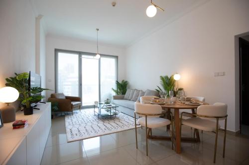 a living room with a table and a couch at Noma Fairview - Burj Khalifa view stunning apartment in Business Bay in Dubai