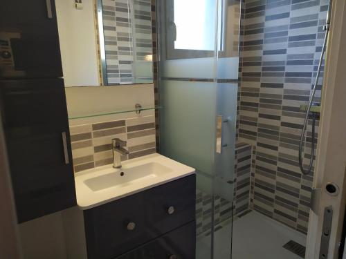 ein Badezimmer mit Waschbecken und Glasdusche in der Unterkunft Beau studio avec grande terrasse in La Grande-Motte