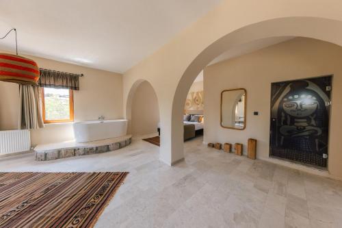 ギョレメにあるCappadocia Aishe Hotelの広いバスルーム(バスタブ付)、ベッドルーム1室が備わります。