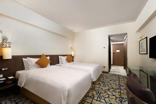 a hotel room with two beds and a window at Grand Noble Hotel Xi’an in Xi'an