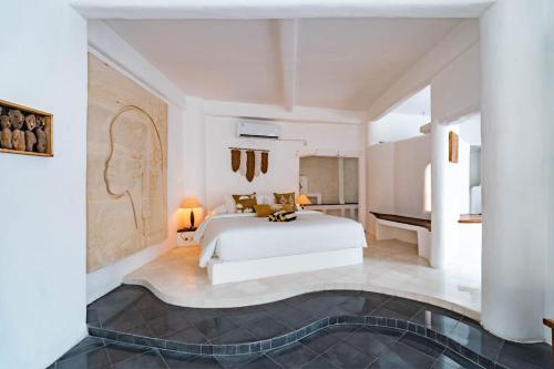 a bedroom with a white bed in a room at La Santa Rosa in Uluwatu