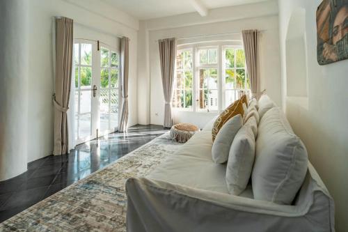 a large white couch in a living room with windows at La Santa Rosa in Uluwatu