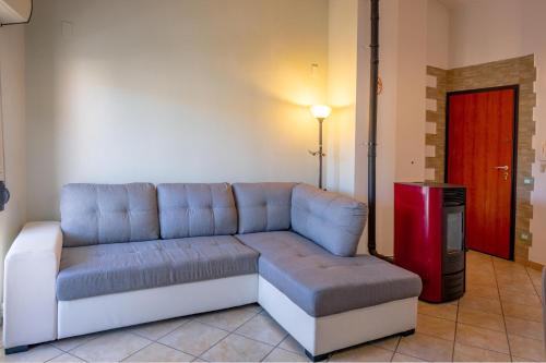 a living room with a couch and a red door at Sestu house in Sestu