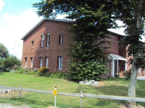 a brick house with a tree in front of it at Haus Denker in Brunsbüttel