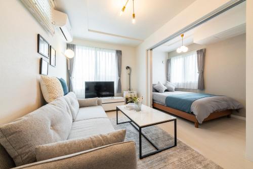 a living room with a couch and a bed at Utopia in Sapporo