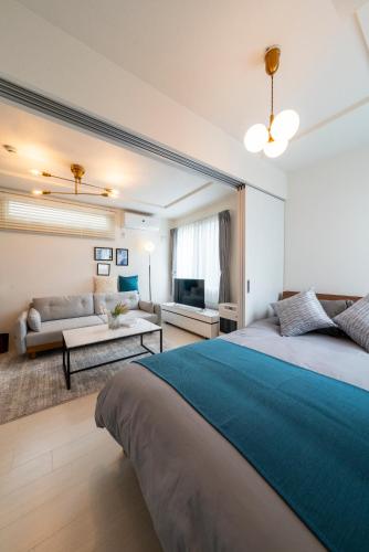 a bedroom with a large bed and a living room at Utopia in Sapporo