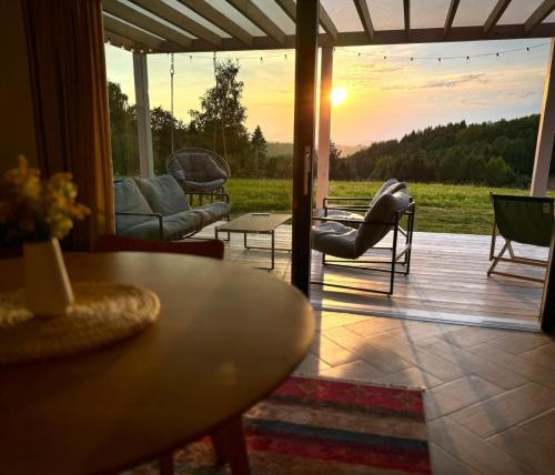 a living room with a table and a view of a field at Chatka ChoćCo in Ryglice